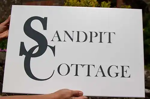 White Painted House Sign With Black Text