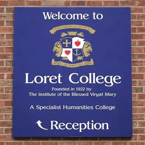 Blue aluminium tray sign with folded returns mounted to brick wall